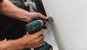 closeup of handyman using drill on wall