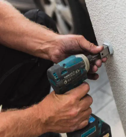 closeup of handyman using drill on wall